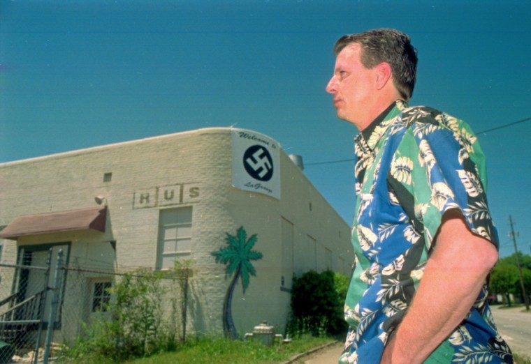 Pub owner John "Rusty" Houser talks with a reporter under a banner he displayed in 2001 to compare a LaGrange City Council decision to pull his alcohol license to Nazi tactics.