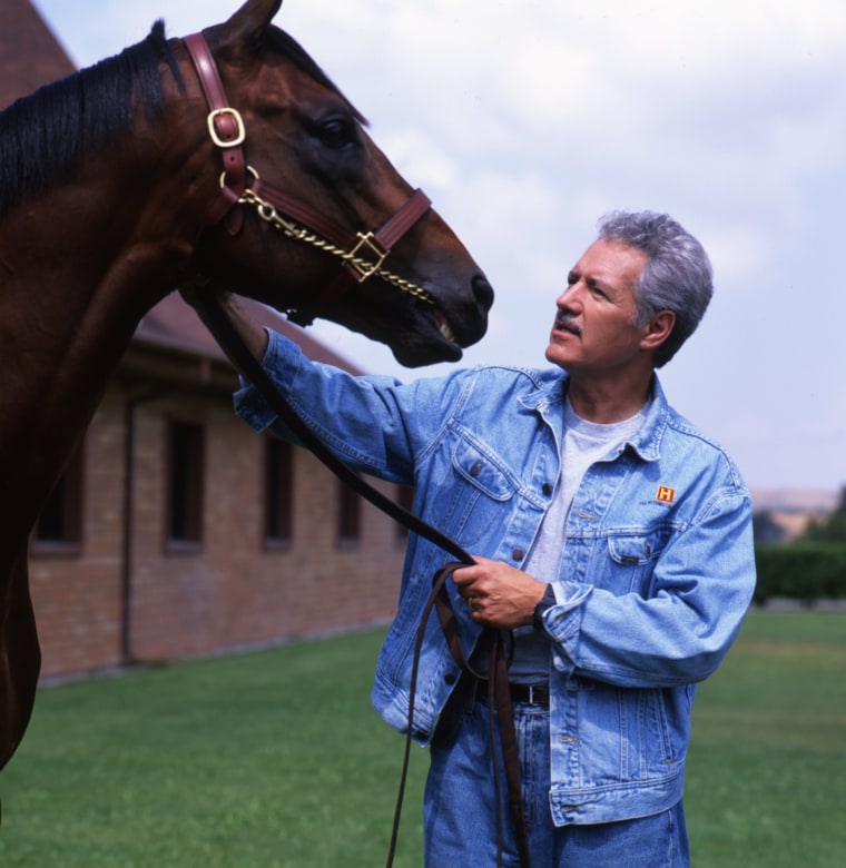 Jeopardy Game Show host Alex Trebek poses for a portrait session with a horse in 1997 in Los Angeles, California.