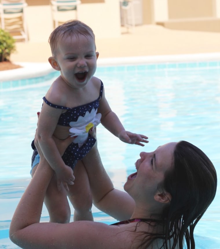 Mom playing with daughter in pool