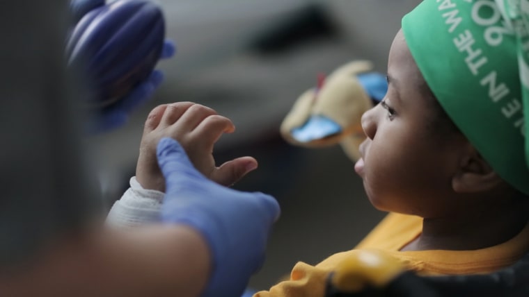 Image: Zion Harvey, 8, looks at his new hand after receiving a bilateral hand transplant earlier this month.