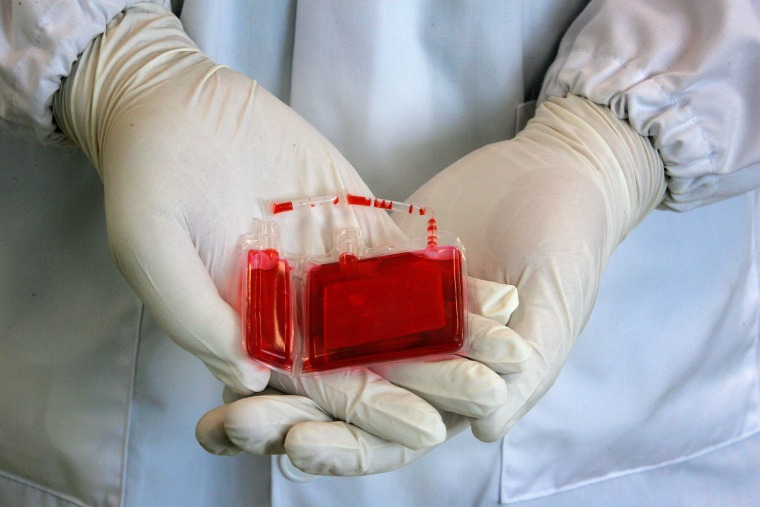 A biotechnologist displays a mock cord blood sample at a Singapore laboratory August 26, 2005. .