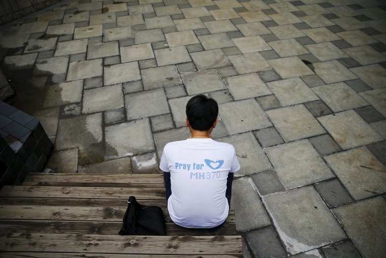 Image: Jiang Hui, whose mother was on MH370, checks news of the debris discovery