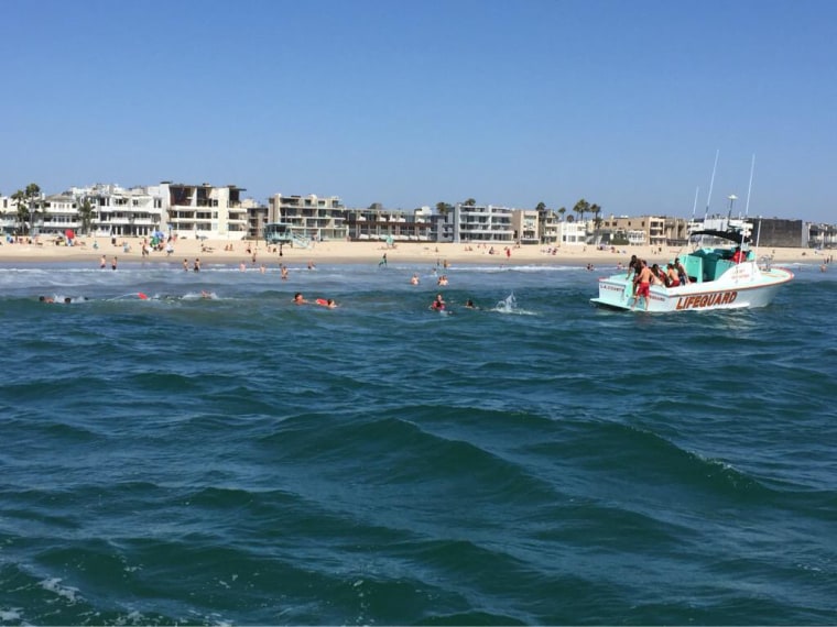 Los Angeles County Fire Dept. lifeguards respond aid swimmers caught in a fast-moving current, known as a "blitz,"  at Venice Beach on Tuesday. Eighteen people had to be rescued.