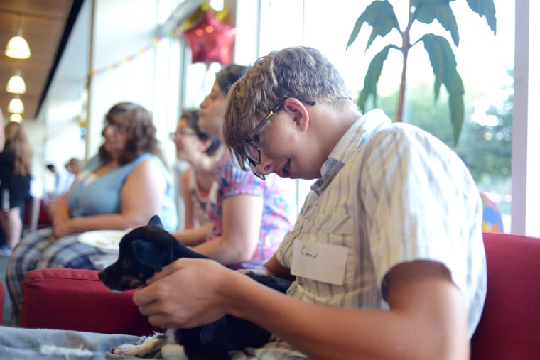 Conner Loescher, 13, of Merchantville, New Jersey, holds Sprout, a small rescue with a cleft lip.