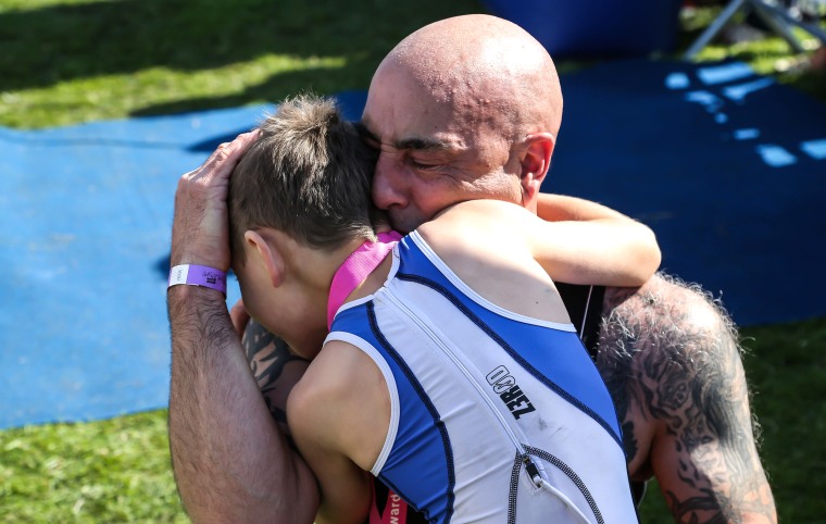 Bailey Matthews, 8-year-old with cerebral palsy who finished a triathalon, celebrating at the finish line