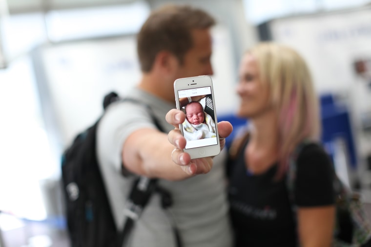 The Olsons show a photo of the baby they are about to meet and adopt.