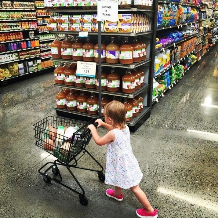 Toddler pushing grocery cart