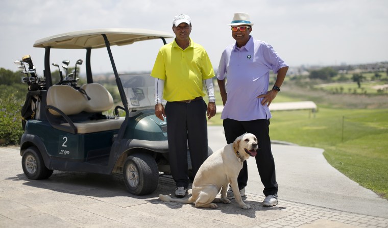 Blind golfer Zohar Sharon, right, and caddy Shimshon Levy on a fairway in Caesarea, Israel.
