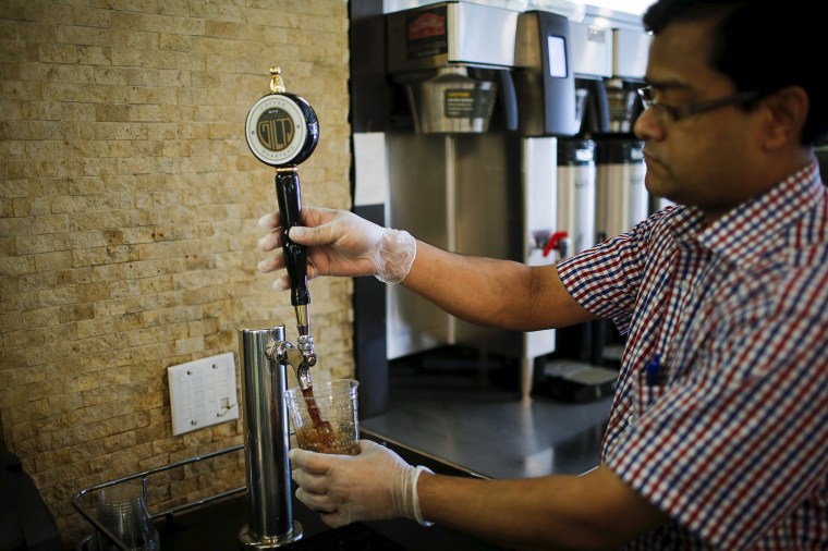 Image: A Guy &amp; Gallard cafeteria employee serves a nitrogen-infused cold brew coffee from Brooklyn-based roaster Gillies Coffee out of a tap at its cafeteria in New York