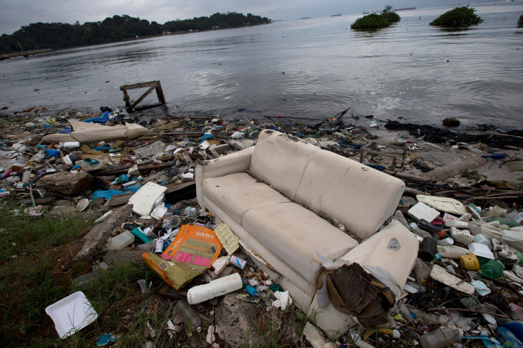 Image: A discarded sofa litters the shore of Guanabara Bay in Rio