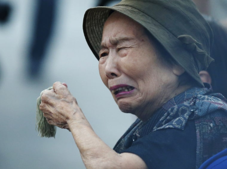 Image: Woman reacts as she prays for atomic bomb victims in front of the cenotaph for the victims of the 1945 atomic bombing, at Peace Memorial Park in Hiroshima