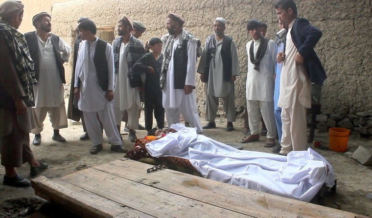 Image: Relatives stand over bodies of victims of gunfight at wedding party in Deh Salah, Afghanistan