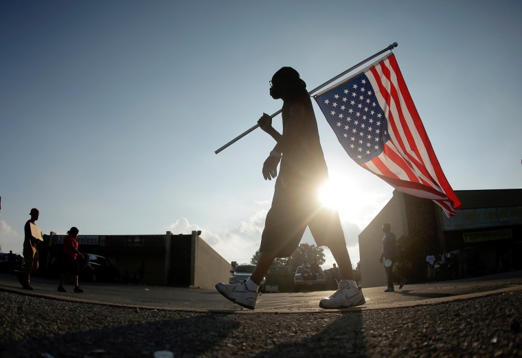 Duane Merrells walks with an upside down flag in a protest for Michael Brown on August 18, 2014.