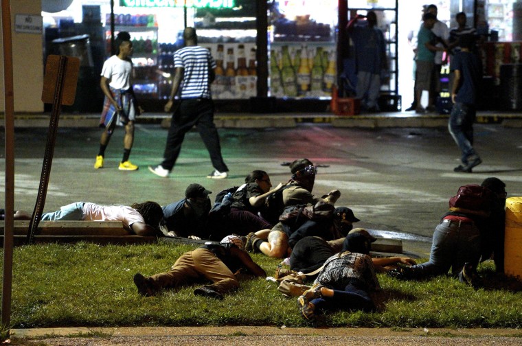 Image: Protesters fall to the ground to take cover after shots were fired in Ferguson, Missour