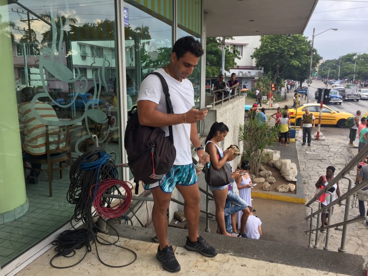 Image: In Havana, Cuba, people congregate around some new Wifi hotspots once or a few times a week.  The service is spotty and expensive.