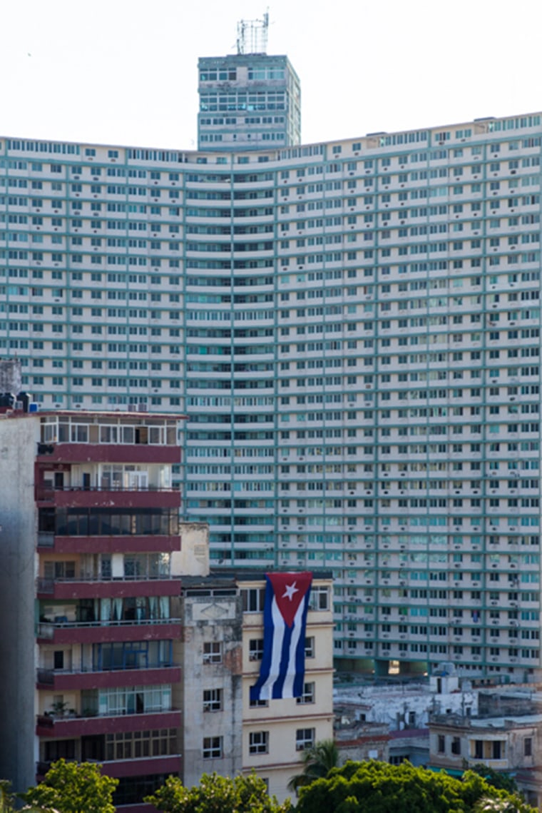 A large Cuban flag is unfurled on a building near the Hotel Nacional, one of many flags unfurled around the city as the U.S. Embassy prepares to raise its flag on Friday.