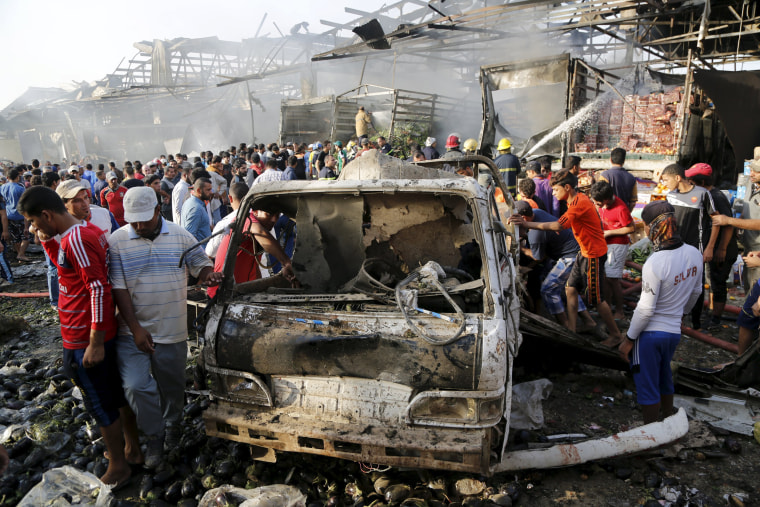 Image: Residents gather at the site of a truck bomb attack at a crowded market in Baghdad