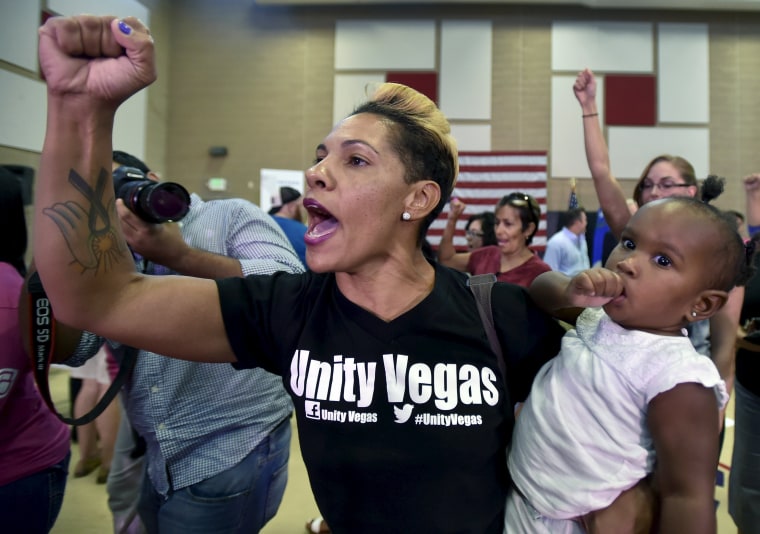Image: Tenisha Martin of Las Vegas, holding her daughter Maddie, yells \"black lives matter\" after Republican presidential candidate Jeb Bush spoke at a town hall meeting in North Las Vegas