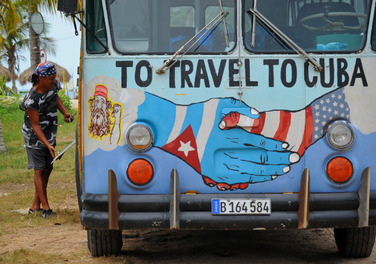 Image: A bus with the Cuban and US flags is seen on a beach in Havana