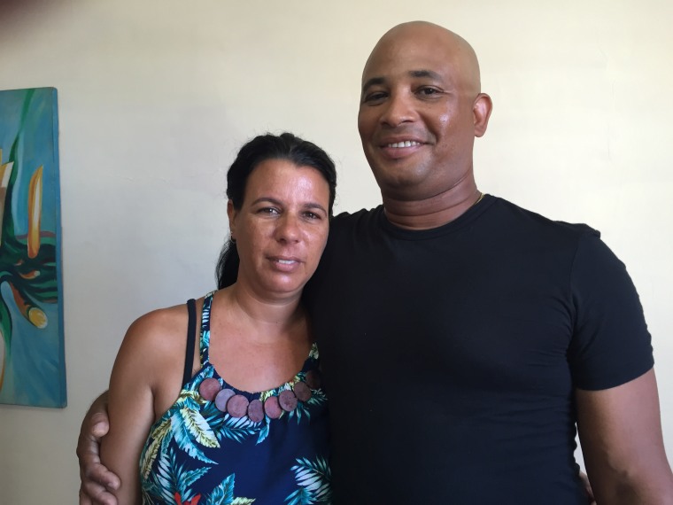 Caption: Ailén Corcho with her husband Alberto Amorós at home in Havana, Cuba, gathered with family to watch the U.S. Embassy flag raising on August 14, 2015. "It's very difficult with divided family - they should just reestablish ties now with not as many hassles." 
Credit: Sandra Lilley