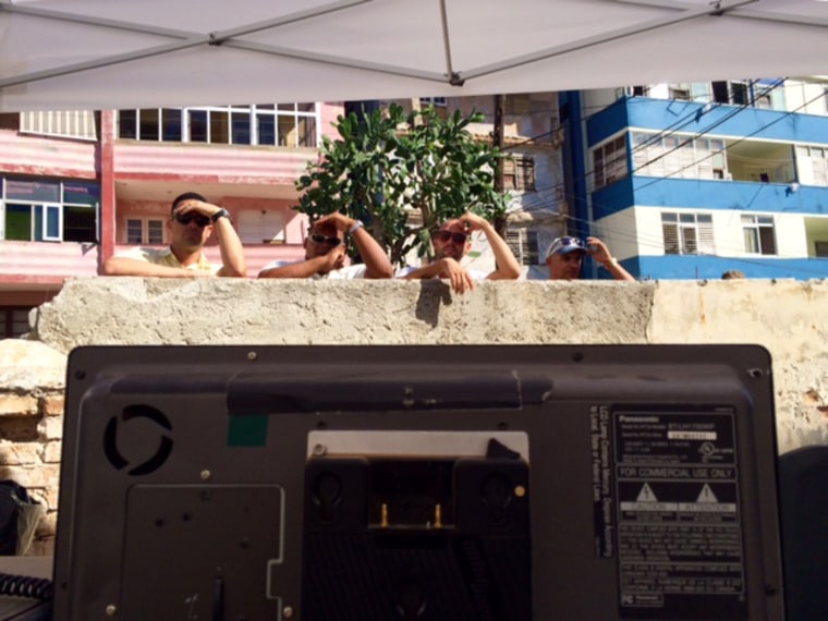 In Havana under the hot sun, spectators wait for Secretary of State John Kerry to speak at the U.S. Embassy flag-raising ceremony.