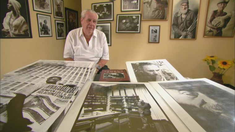 Roberto Salas displays some of his photographs, one of which was taken on the day the American embassy closed in Havana.