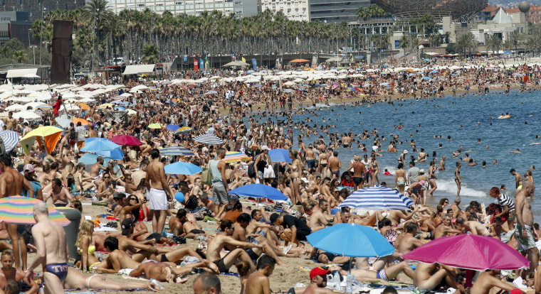 Image: People cool off at Sant Sebastia beach in Barceloneta neighbourhood in Barcelona