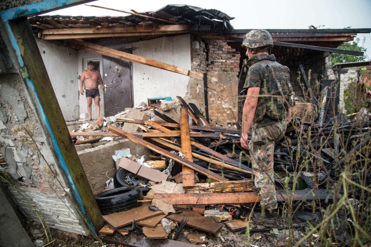Image: A Ukrainian serviceman examine a destroyed house after shelling between Ukrainian forces and pro-Russian seperatists