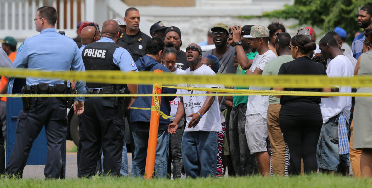 Image: People confront police at the scene of a fatal officer-involved shooting at Walton Avenue