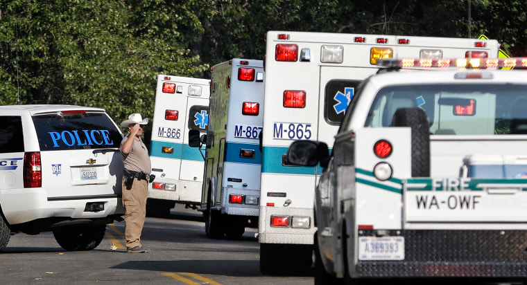 Image: Twisp Police Chief Paul Budrow salutes as ambulances carry the bodies of three firefighters