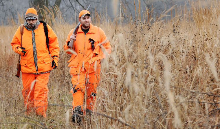 Rick Forster, left, and Sean McCarthy, both of Eau Claire, head out of the woods after deer hunting on Nov. 19, 2011, near Carryville, Wisconsin.