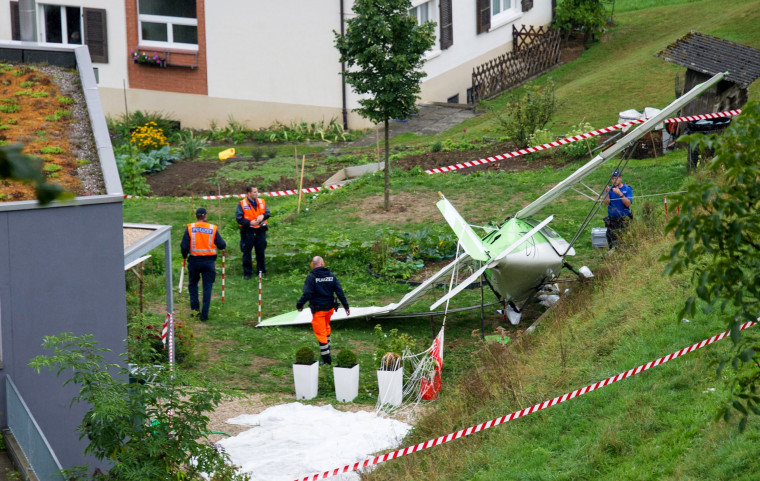 Image: Swiss police officers inspect the wreckage of a plane involved in a collision with a second plane during an airshow on August 23, 2015 in Dittingen, near Basel, northern Switzerland