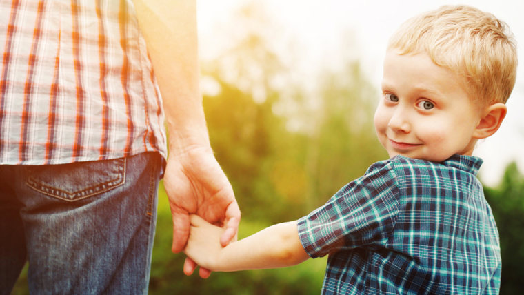 Boy holding a persons hand