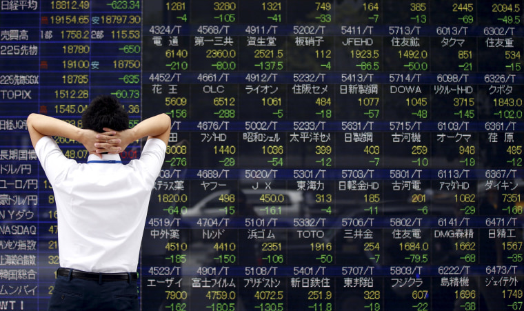 A man looks at a stock quotation board outside a brokerage in Tokyo, August 24, 2015. Asian stocks plunged to 3-year lows on Monday as a rout in Chinese equities gathered pace, hastening an exodus from riskier assets as fears of a China-led global economic slowdown roiled world markets.  