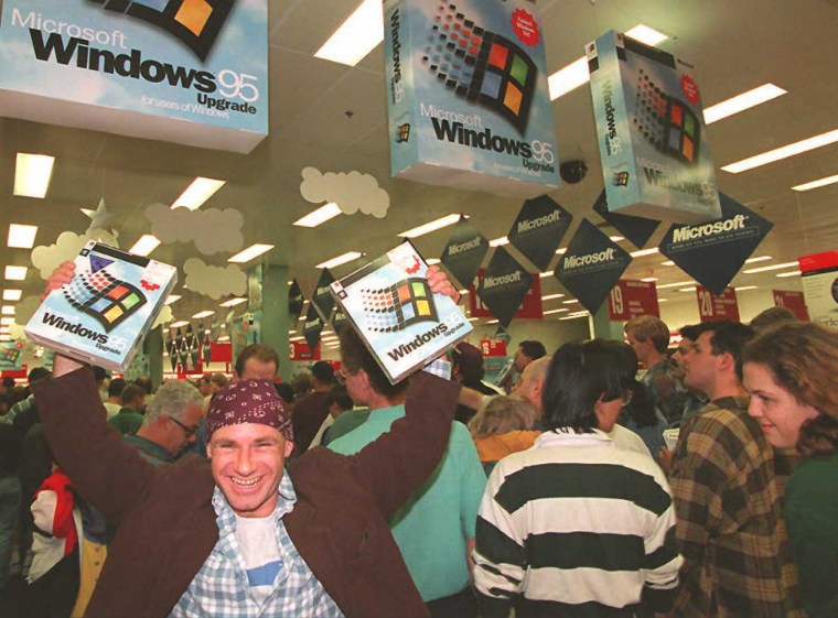 Image: Mikol Furneaux waves two packages of Windows 95 software in the first store in Australia to sell the product