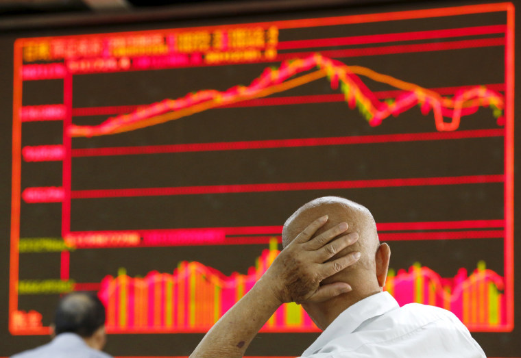 Image: An investor looks at an electronic board showing stock information at a brokerage house in Beijing