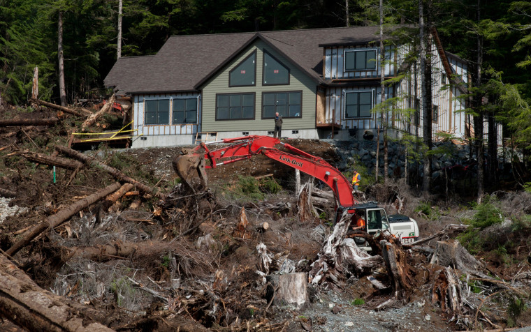 Image: Sitka City Administrator Mark Gorman stands in front of a house on Kramer Avenue as contractors and other search members look for William Stortz