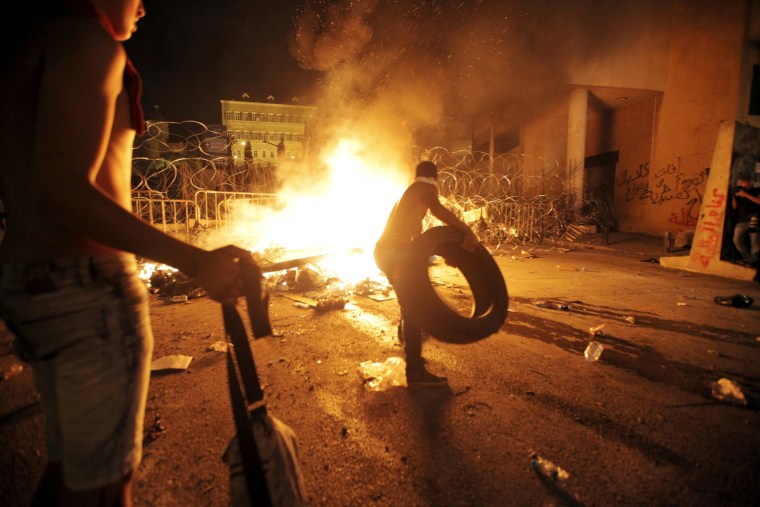 Image: Protesters start a fire during a protest against corruption and against the government's failure to resolve a crisis over rubbish disposal, in front of the government palace in Beirut, Lebanon
