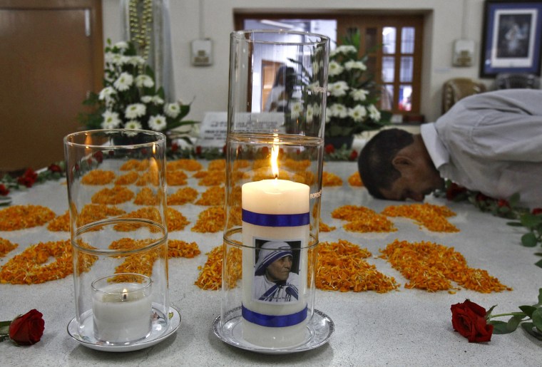 Image: A man prays near image of Mother Teresa on candle, during ceremony to mark her 105th birth anniversary, at her tomb in Kolkata