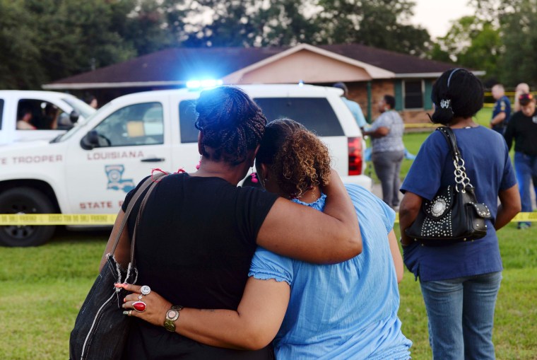 Image: Tafara Hayes and Rose Sonnier embrace as they watch police investigate