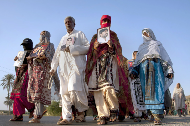 Image: Baloch families hold photographs of their relatives