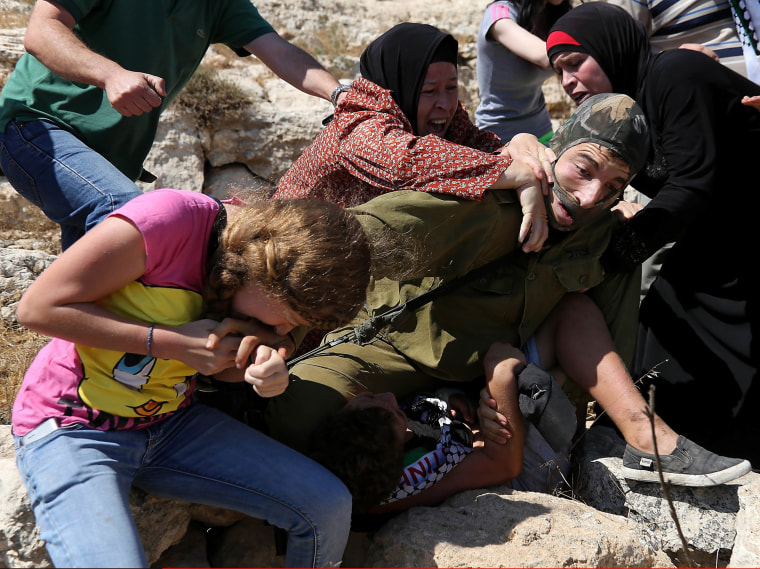 Image: Ahed Tamimi bites a masked Israeli soldier in the midst of a melee