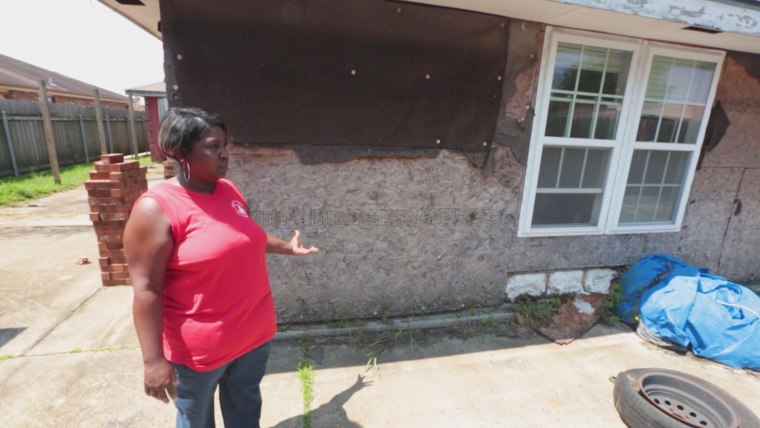 Image: Janice Tambrella outside her damaged and unfinished home.