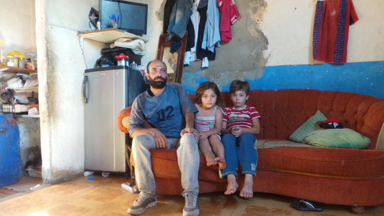 Image: Abdul Halim, 35, in his threadbare southern Beirut apartment with daughter Reem, 4, and son