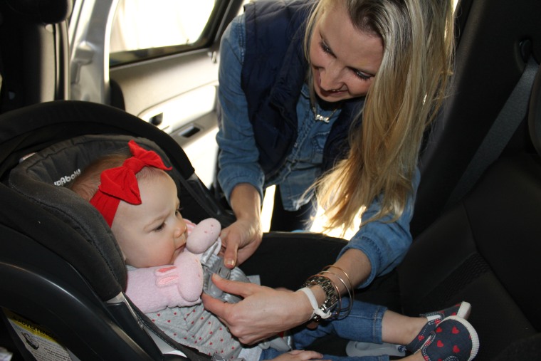Marcie Miller straps her daughter Brooklyn into a car seat.