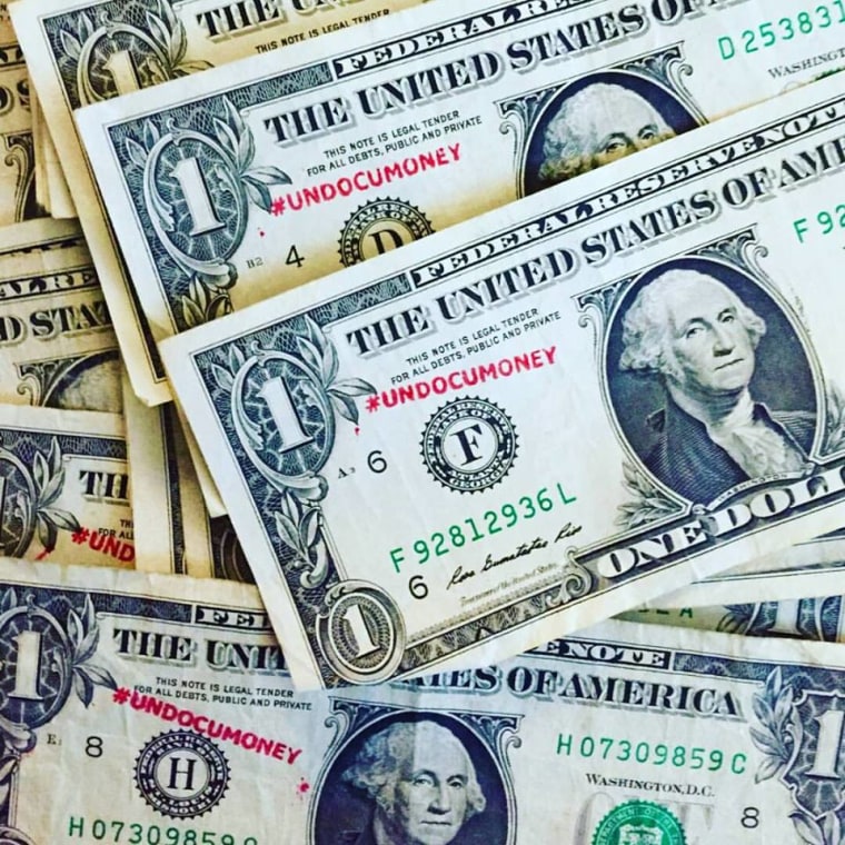 People are being asked to write the hashtag #undocumoney on dollar bills in red ink and to post a photo on social media of themselves holding the dollar bills as part of a campaign that aims to highlight the economic contributions of undocumented immigrants.