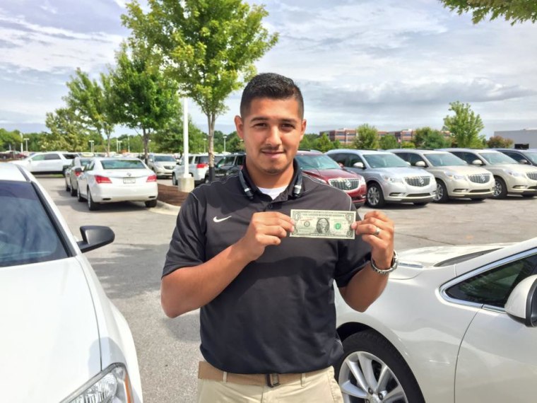 A participant of the #undocumoney campaign, Marco Enriquez shows off a red-inked dollar bill.