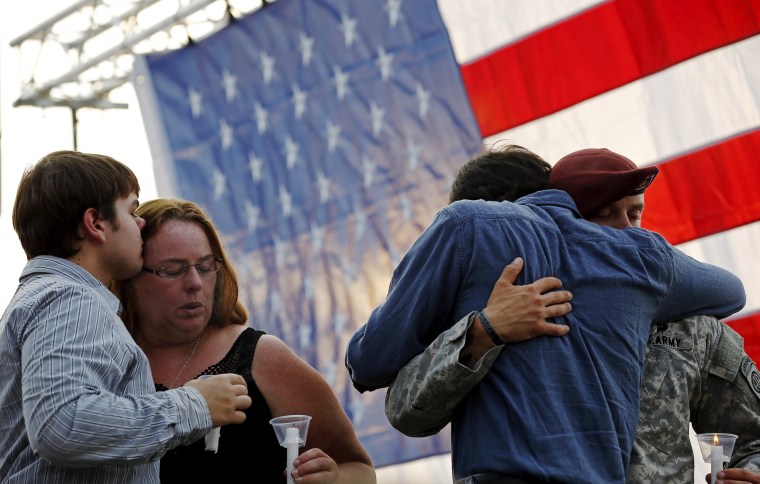 Image: Mel Gliniewicz, wife of slain Fox Lake Police Lieutenant Charles Joseph Gliniewicz is comforted by their children at a vigil in Fox Lake