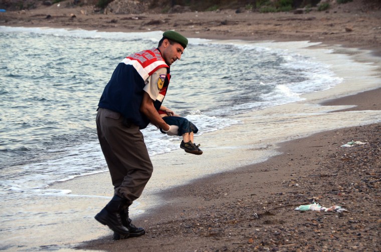 Image: A paramilitary police officer carries the lifeless body of a migrant child
