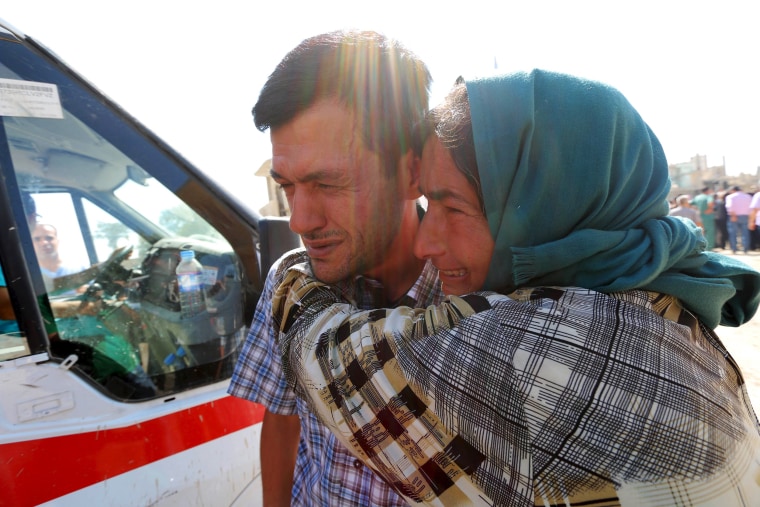 Image: Abdullah Kurdi mourns with his relative during the funeral of his toddlers at the Syrian border town of Kobani